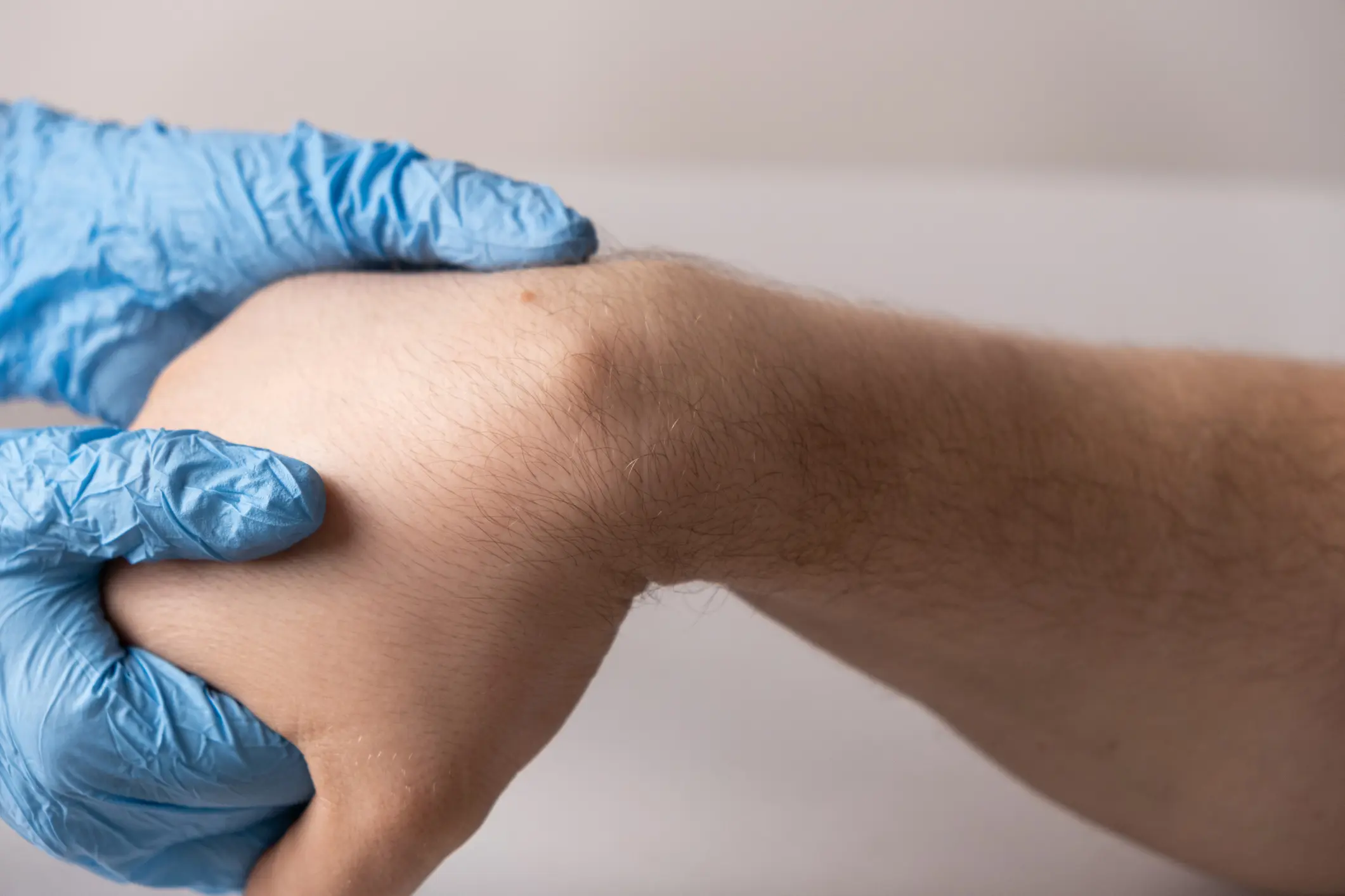 Gloved hand holding another person's wrist
